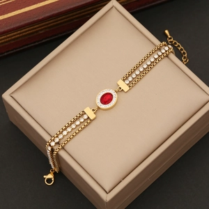 Golden triple-layer chain bracelet with central red zircon and sparkling accents