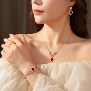 Vintage gold jewelry set with red zircon stones featuring necklace, earrings and ring
