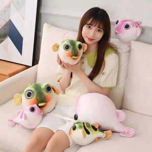 Mannequin assis sur un canapé avec d'adorables peluches de poisson-globe vertes et roses