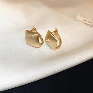 Boucles d'oreilles créoles carrées en or brossé avec finition mate sur soie blanche