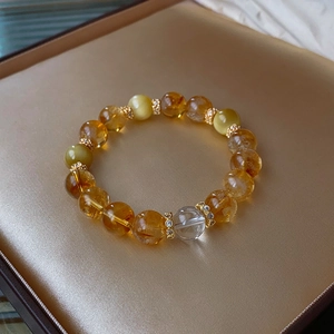 Close-up of white crystal beaded bracelet with gold spacers on a golden display tray