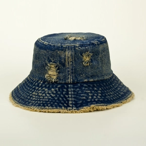 Detail of distressed dark blue denim bucket hat with ripped holes and frayed edges