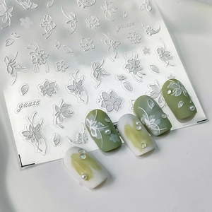 5D embossed white floral nail stickers with frosted texture on green and cream nails