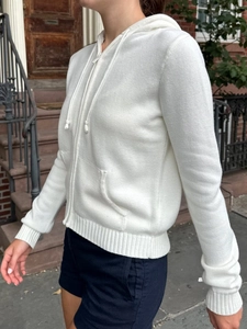 Détail d'un sweat à capuche en maille blanche avec poignets côtelés et poche kangourou