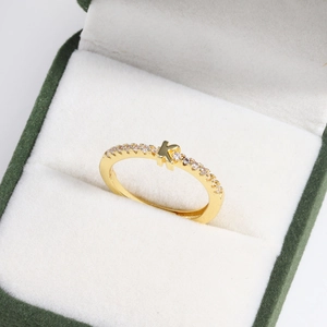 Close-up of 18k gold plated letter K ring with diamonds in a green velvet jewelry box