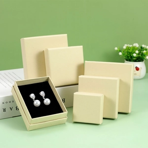 Elegant beige jewelry gift boxes in various sizes with black foam inserts on green background