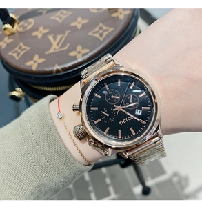 Close-up of rose gold watch with black dial and metal mesh strap on model wrist