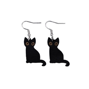 Detail of wooden black cat earrings with skull accents and silver metal hooks