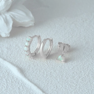 Detailed view of S925 sterling silver evil eye earring set with opal on white background