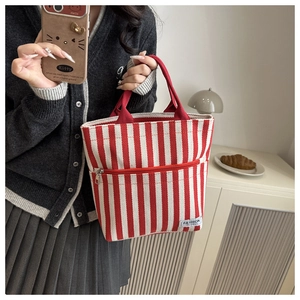 Macro shot of red and white striped canvas tote with Fashion Instinct label and zipper pocket