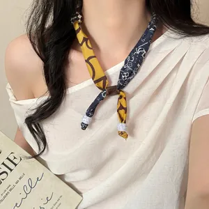 Detail view of leopard print silk scarf necklace with brown buckle and marble beads