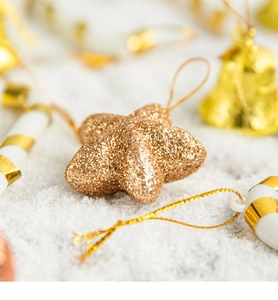 Macro shot of glittery gold star ornament with hanging string for Christmas tree decor