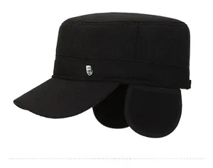 Close-up of a black winter flat top hat featuring a protective earflap and a metal logo