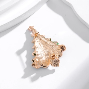Back view of a gold Christmas tree brooch with standard pin clasp on a white background