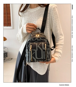 Detail of a mini grey letter-print backpack with golden zippers on a female model
