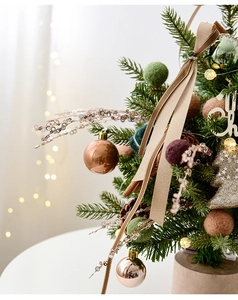 Macro detail of luxury mini Christmas tree with PE needles, bronze balls and warm LED lights