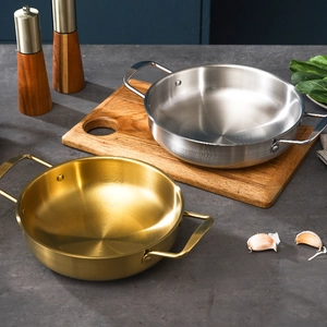 Polished stainless steel shallow pans with dual handles in gold and silver finishes