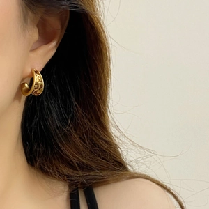 Vintage style gold hollow C-shaped enamel earrings worn by a model for a classic look