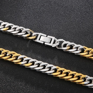 Two-tone gold and silver Cuban link necklace with rectangular clasp on black background