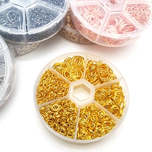 Close-up of assorted jewelry jump rings in various metallic finishes stored in round organizers