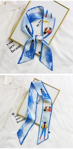 Detail of sky blue silk twilly scarf with daisy patterns and artistic floral illustrations