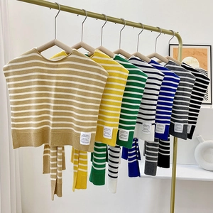 Striped knit false collar shawls in various colors hanging on a gold rack display