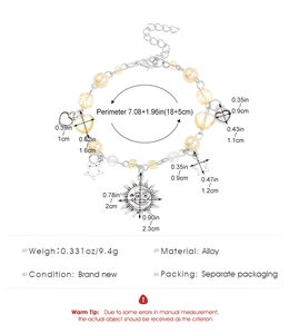 Detail view of y2k beaded bracelet with sun moon pendants and heart charms in cream white