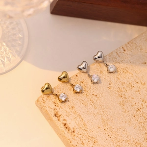 Elegant heart tassel zircon stud earrings in gold and silver finish on stone tray