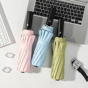 Three automatic folding umbrellas in pink, blue, and green with matte black handles