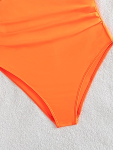 Close-up of bright orange one-piece swimsuit with ruched sides and high-cut leg detail
