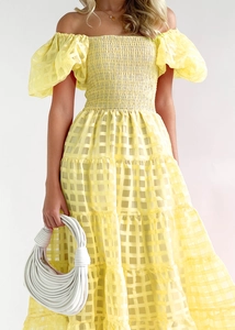 Detail of yellow off-shoulder tiered maxi dress with puff sleeves and textured fabric