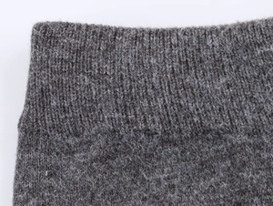 Vista macro de tejido de punto acanalado gris con textura suave y detalles de hilo