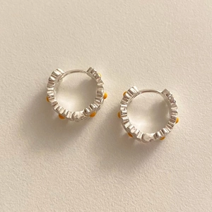 Detailed close-up of 925 sterling silver hoop earrings with yellow daisy pattern