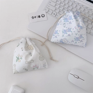 Close-up of cute cartoon drawstring pouches with rabbit and teddy bear floral prints