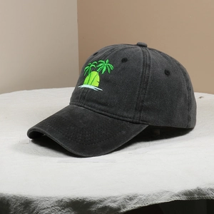Close-up of green palm tree embroidery on a dark grey washed cotton baseball cap