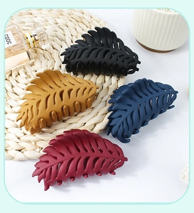 Macro shot of matte leaf hair claws in black, yellow, navy, and dark red colors