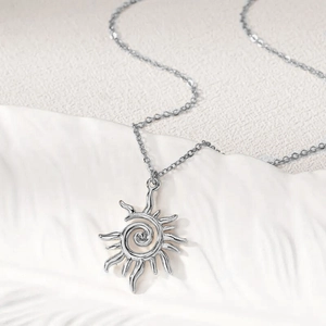 Detail shot of vintage silver alloy sun swirl pendant with intricate hollow design