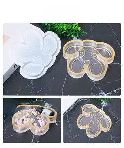 Detail of dog-shaped silicone mold and gold-edged resin tray on black marble