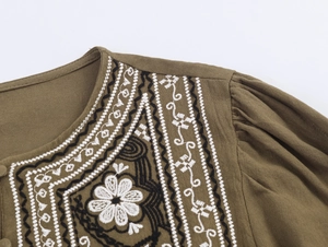 Détail de la broderie florale bohème sur l'encolure et l'épaule du chemisier vert olive