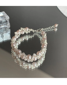 Close-up of pink imitation pearl beaded bracelet with sparkling crystal accents and metal clasp
