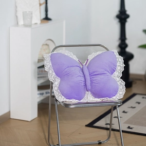 Detailed view of butterfly plush pillow with white lace trim and soft purple velvet fabric