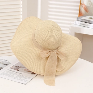 Elegant wide brim straw sun hat with bow on minimalist white background for summer vacation