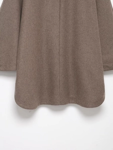 Dettaglio dell'orlo posteriore di un cappotto di lana marrone con trama del tessuto