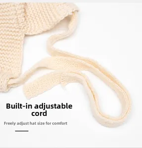 Detail of the adjustable inner drawstring for a custom fit on a cream knit beanie