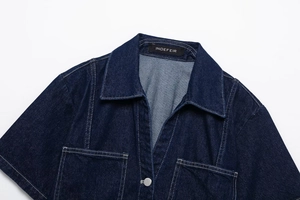 Close-up of dark blue denim shirt collar with white contrast stitching and logo label