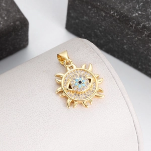 Macro view of gold-plated sun-shaped evil eye pendant with blue and clear zircon stones