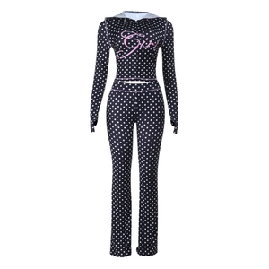 Detailed flat lay of black polka dot tracksuit set with pink Girl print on the hoodie