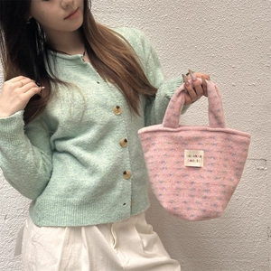 Detailed close-up of pink felt tote bag with brand label and colorful texture details