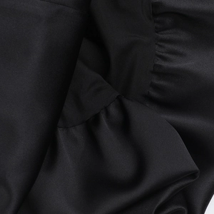 Detailed close-up of the elegant ruched black satin fabric texture and pleated finish