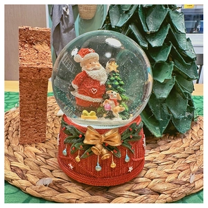 Detailed close-up of a Christmas snow globe music box featuring Santa and a red base